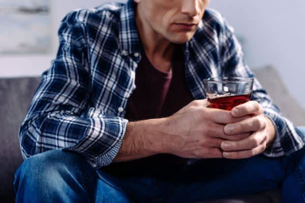 Alcohol and Sleep stock photo of a man holding a glass of alcohol