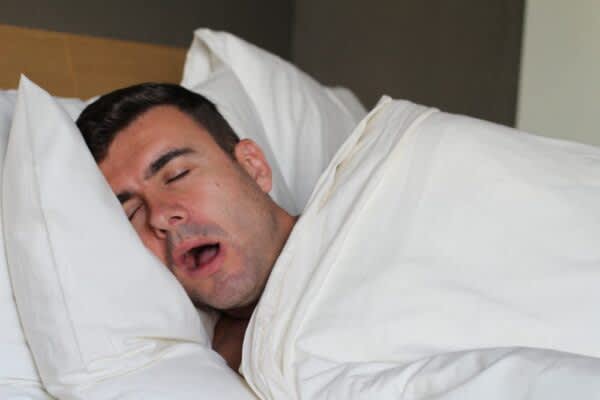 Snoring stock photo of a man sleeping with his mouth open
