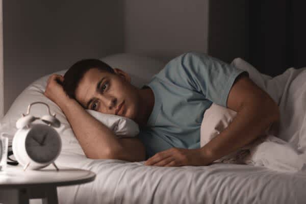 Cognitive Behavioral Therapy for Insomnia (CBT-I): Is It For You? stock photo of a young man suffering from insomnia