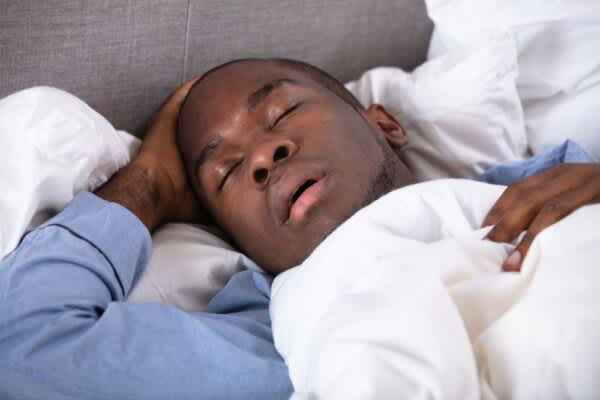 Night Sweats: Causes & Treatments stock photo of a man snoring