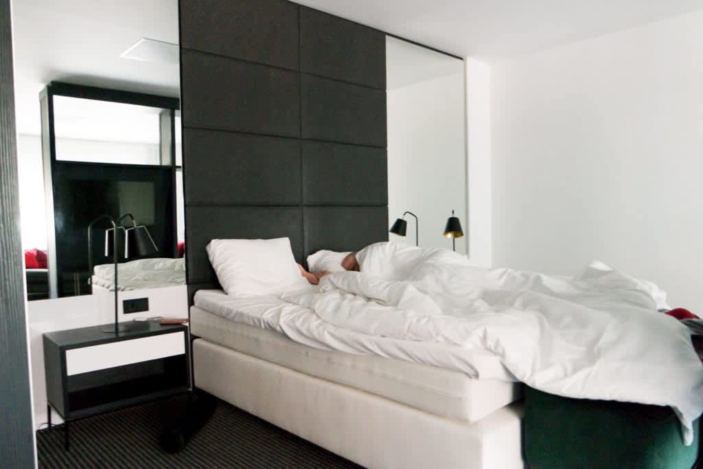 Travel and Sleep: How to Get Quality Rest on Trips Man sleeping in modern hotel room.
