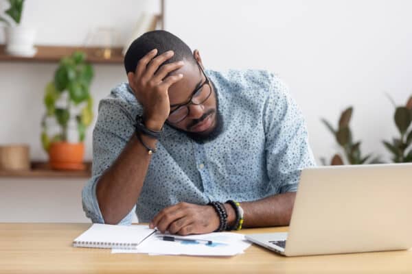 Tired man sitting at desk with computer