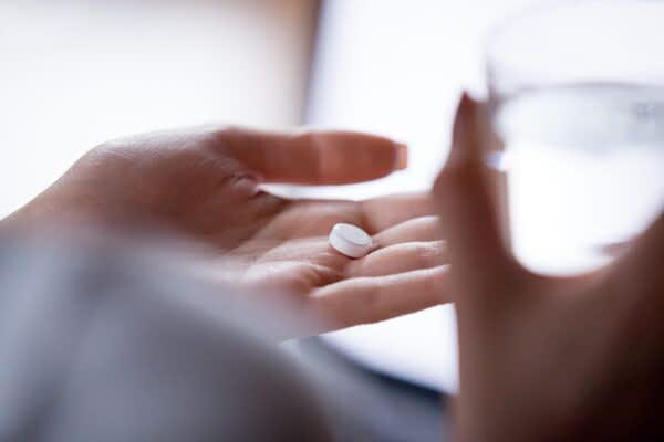 Sleep Aids: Your Guide to Medications and Supplements stock photo of a person taking a pill