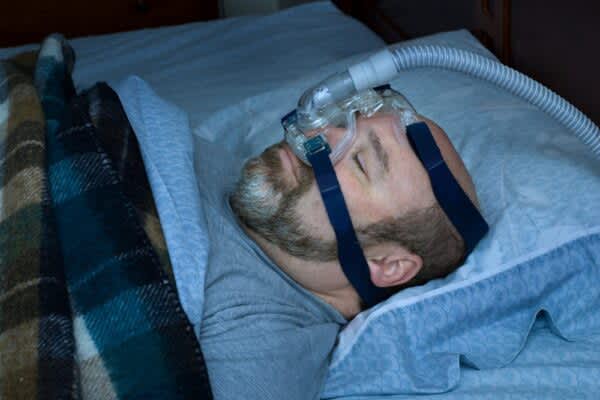 Sleep Apnea Treatment: A Guide to Effective Therapy Options stock photo of a man using a cpap machine