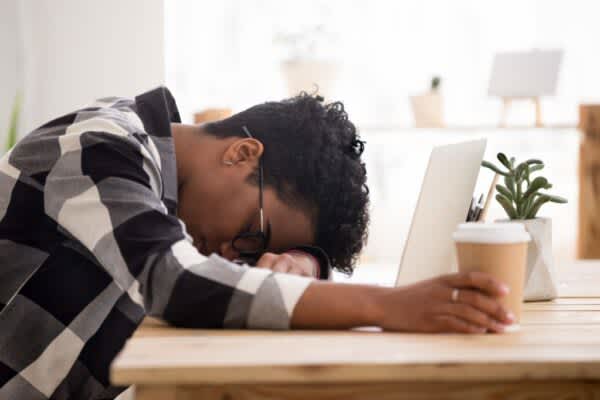 Sleep Deprivation: Definition, Symptoms, & Effects young man resting his head down on a laptop