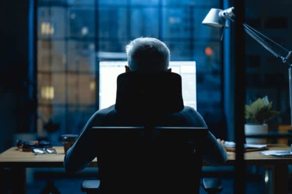 Technology and Sleep stock photo of a person sitting at a computer at night