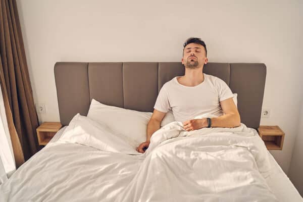 Signs You Are Not Getting Enough Sleep Tired man sitting awake in bed