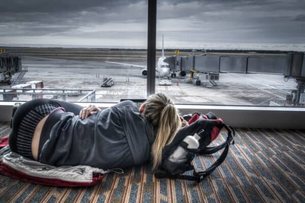female traveler lying on the floor in an airport