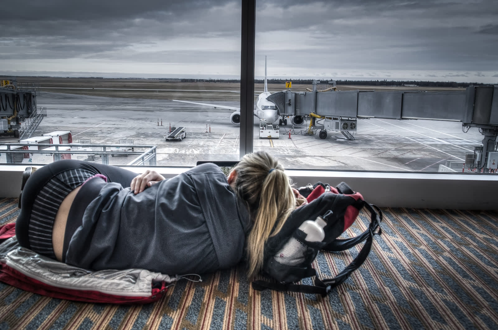 female traveler lying on the floor in an airport