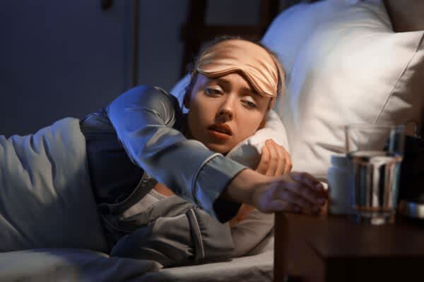 The Best Vitamins for Sleep: Our Experts Weigh in person taking vitamins before bed