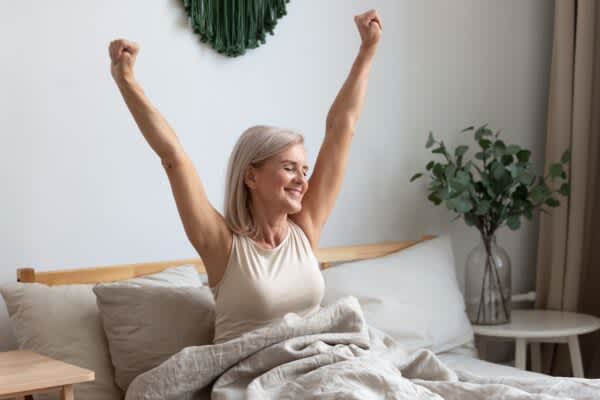Healthy Sleep Tips: Our Guide to Getting Better Rest older woman waking up with a lot of energy