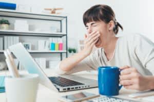 stock photo of a woman yawning while working