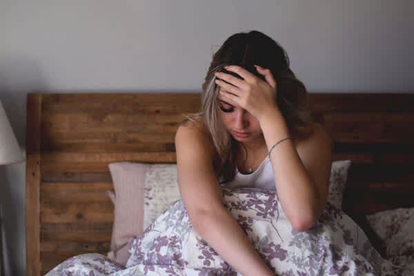 Sleep and Mental Health Young woman sitting in bed feeling stressed